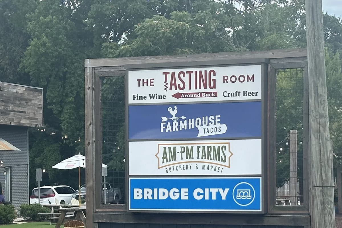 Trailside sign in Travelers Rest listing The Tasting Room, Farmhouse Tacos, AM-PM Farms and Bridge City