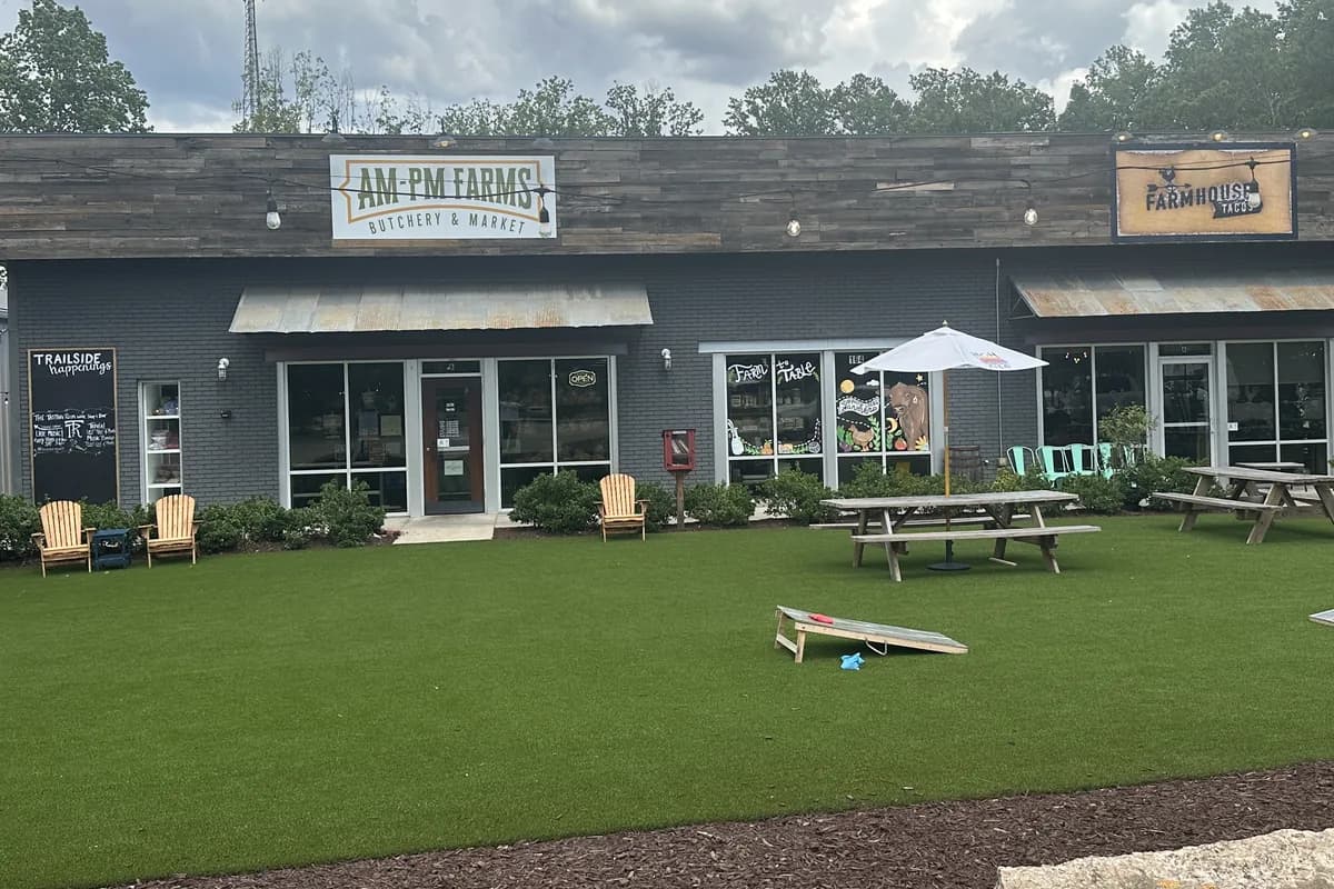 AM-PM Farms Butchery and Market and Farmhouse Tacos at Trailside in Travelers Rest, with a lawn, picnic tables and cornhole