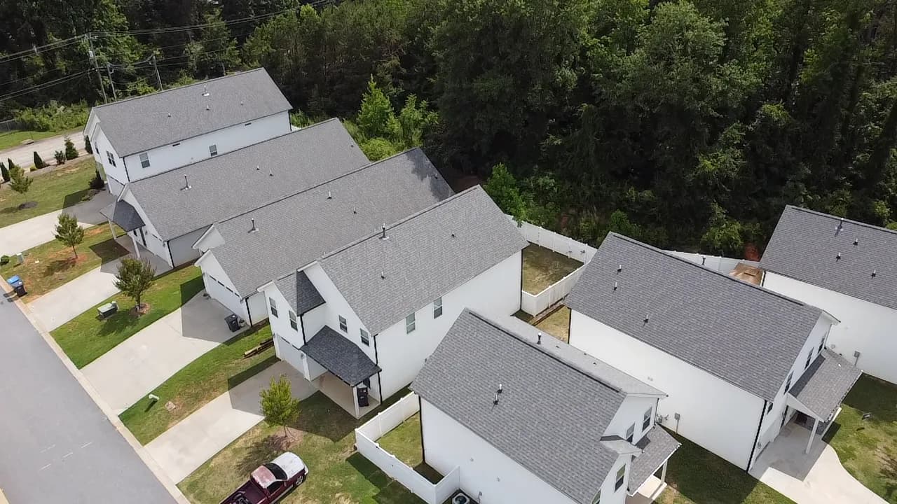 Aerial view of new single family rental homes at Village West in Travelers Rest, South Carolina, backing onto wooded foothills